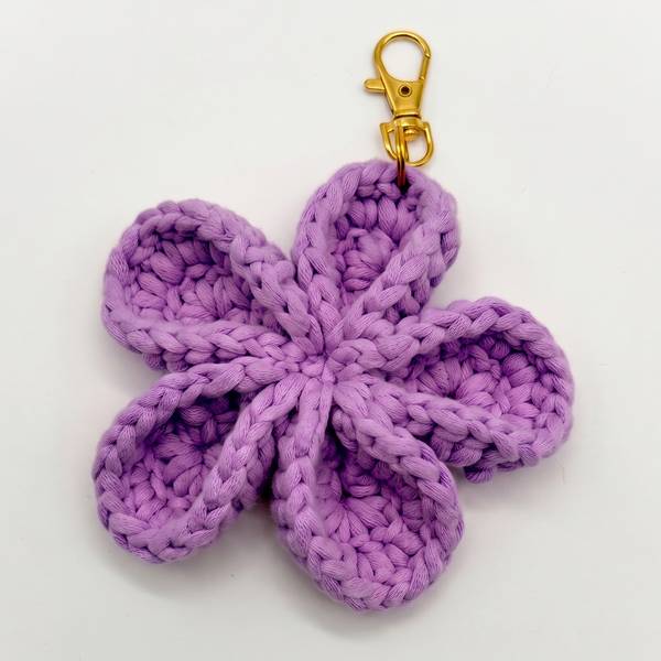 Crocheted flower bag charm with a gold clasp